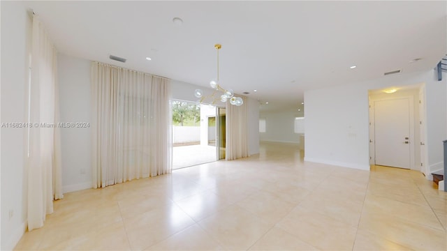 empty room featuring light tile patterned floors and an inviting chandelier