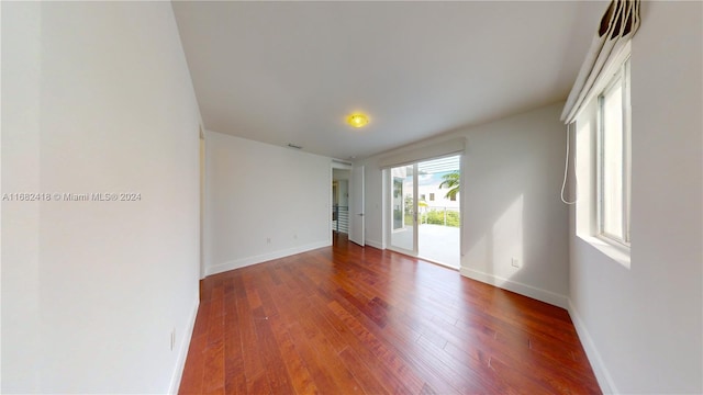 unfurnished room with dark hardwood / wood-style flooring