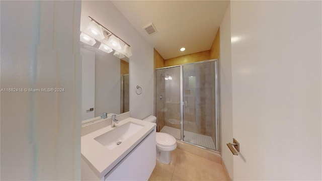 bathroom with vanity, tile patterned floors, toilet, and an enclosed shower