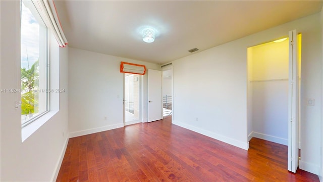 unfurnished room with dark hardwood / wood-style flooring