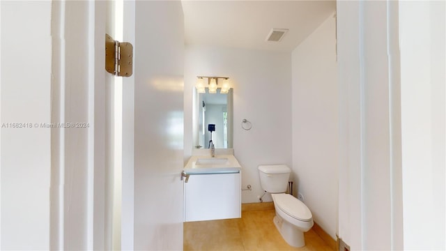 bathroom featuring vanity, hardwood / wood-style flooring, and toilet