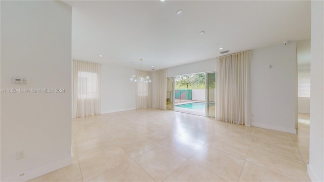 tiled empty room with a chandelier