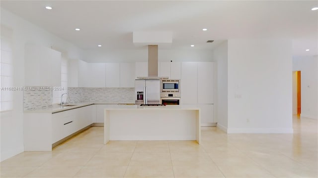 kitchen with decorative backsplash, a kitchen island, stainless steel appliances, sink, and white cabinets