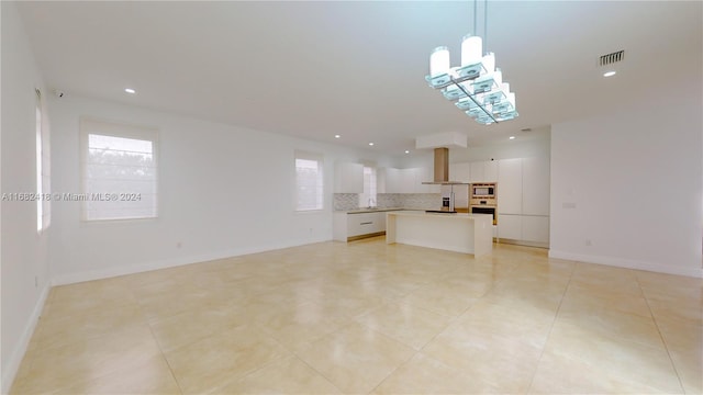 unfurnished living room featuring a healthy amount of sunlight and light tile patterned floors