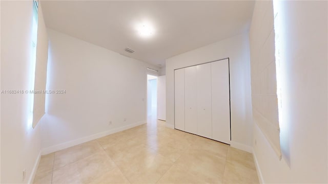 unfurnished bedroom with a closet and light tile patterned flooring