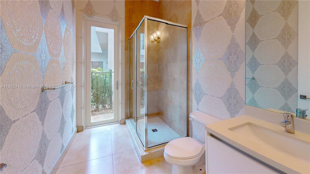 bathroom featuring vanity, toilet, tile patterned flooring, and an enclosed shower