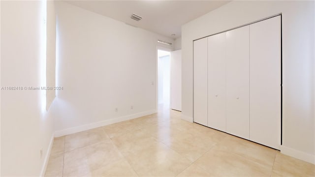 unfurnished bedroom featuring a closet and light tile patterned flooring