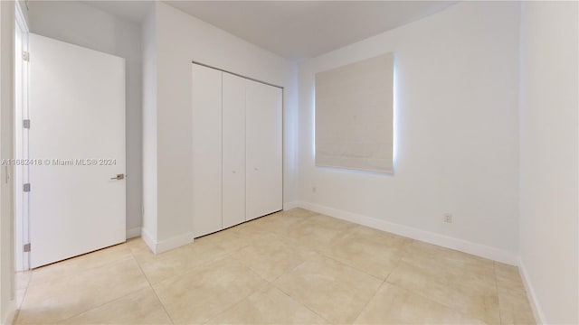 unfurnished bedroom featuring a closet and light tile patterned floors