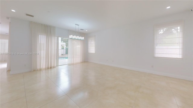 tiled spare room featuring a healthy amount of sunlight