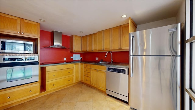 kitchen featuring appliances with stainless steel finishes, sink, and wall chimney range hood