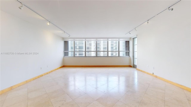 unfurnished room featuring track lighting