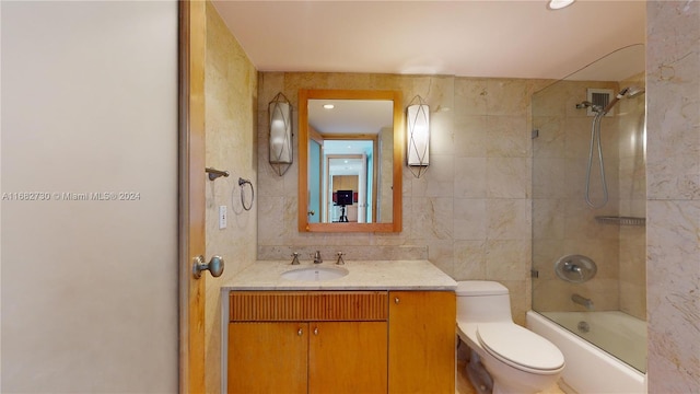 full bathroom featuring tiled shower / bath, tile walls, vanity, toilet, and decorative backsplash