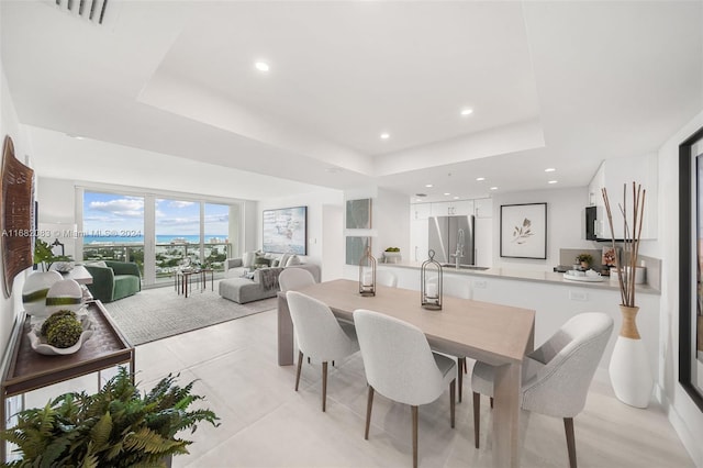 dining space with a raised ceiling