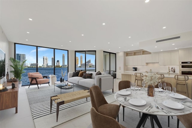 dining space featuring a water view, a healthy amount of sunlight, and floor to ceiling windows