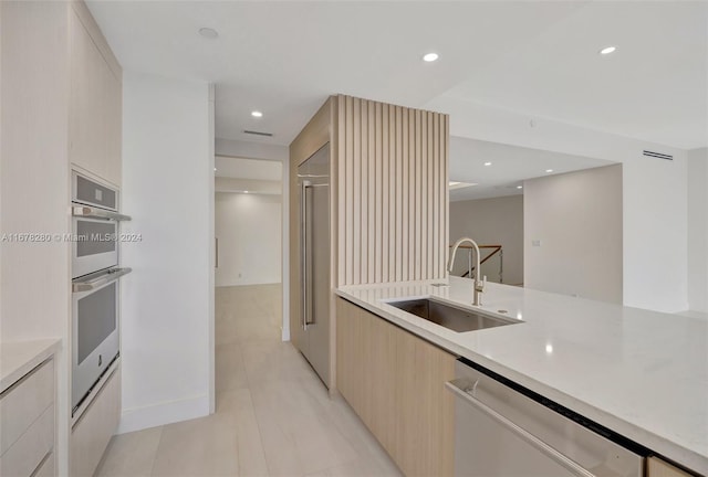 kitchen with sink, light brown cabinetry, and stainless steel appliances