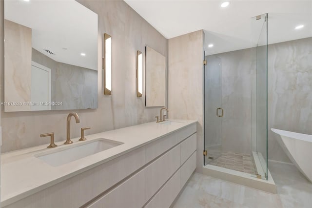bathroom featuring double vanity, a sink, a stall shower, and recessed lighting