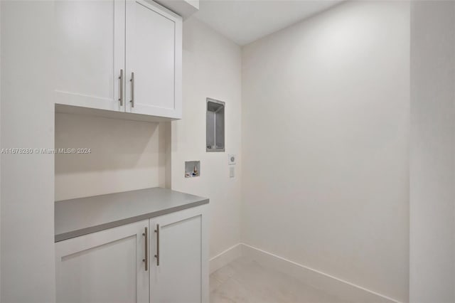 washroom with hookup for an electric dryer, washer hookup, and cabinets