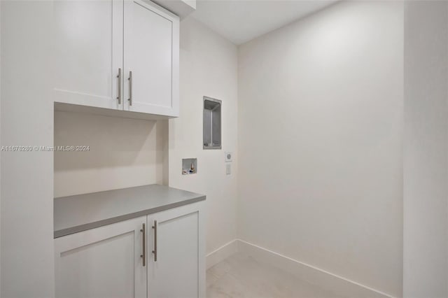 washroom featuring baseboards, hookup for an electric dryer, hookup for a washing machine, and cabinet space