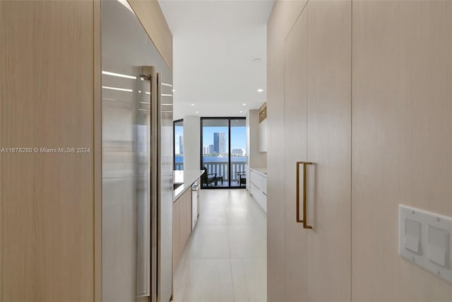 hallway with floor to ceiling windows and light tile patterned floors