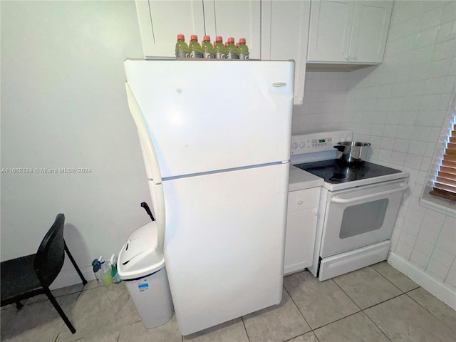 kitchen featuring white appliances, light tile patterned floors, and white cabinets