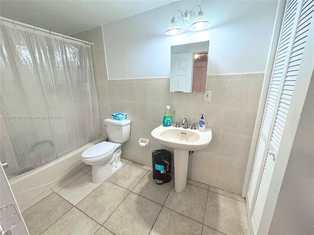 bathroom featuring tile walls, shower / bath combination with curtain, toilet, and tile patterned floors