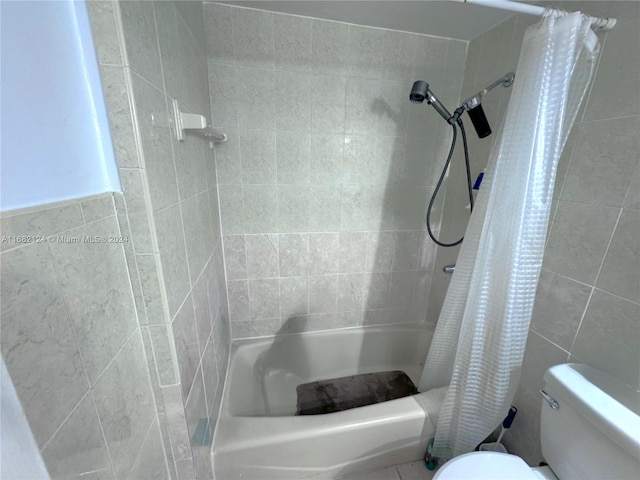 bathroom featuring shower / bath combination with curtain, toilet, and tile walls