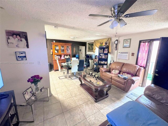 living room with a wall mounted AC, a textured ceiling, light tile patterned floors, and ceiling fan