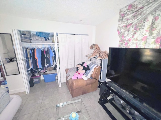 bedroom featuring light tile patterned floors and two closets