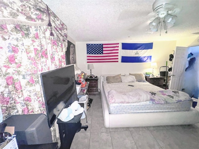 tiled bedroom featuring a textured ceiling and ceiling fan