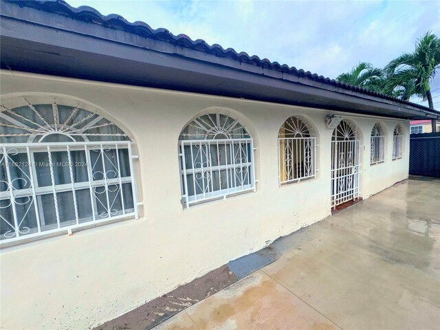 62 NW 73rd Pl, Miami, FL 33126 - view of side of home with stucco siding and a patio