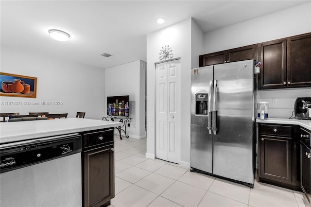 kitchen with dark brown cabinets, light tile patterned floors, and appliances with stainless steel finishes