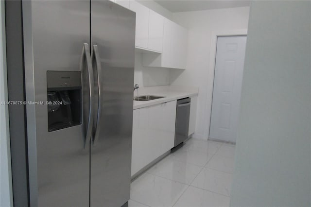 kitchen with white cabinetry, stainless steel appliances, and sink