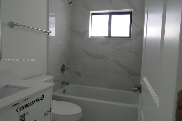 full bathroom featuring tiled shower / bath, vanity, and toilet