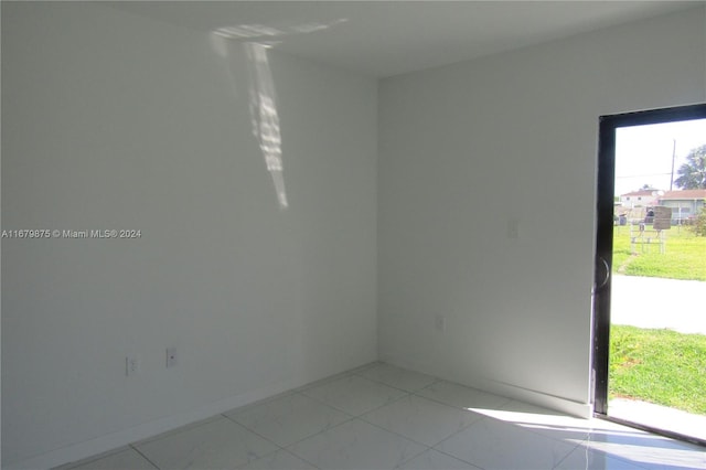 spare room featuring light tile patterned flooring