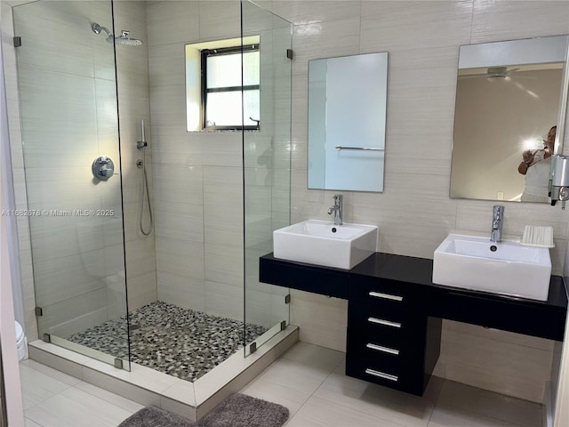 bathroom with tile patterned flooring, toilet, tile walls, and a shower with shower door