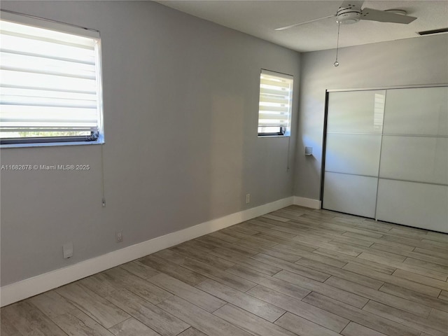 unfurnished bedroom with a closet, ceiling fan, and light wood-type flooring