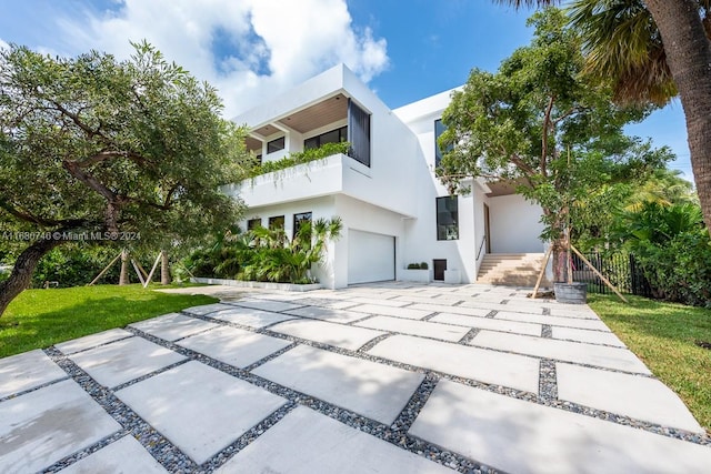 contemporary home with a front lawn and a garage