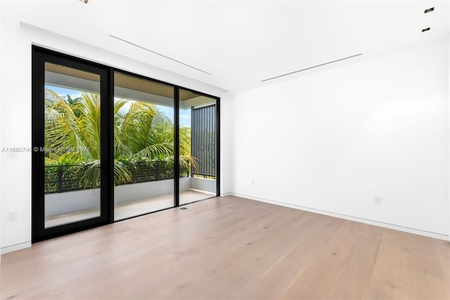 650 Warren Ln, Key Biscayne, FL 33149 - empty room featuring floor to ceiling windows, wood finished floors, and baseboards