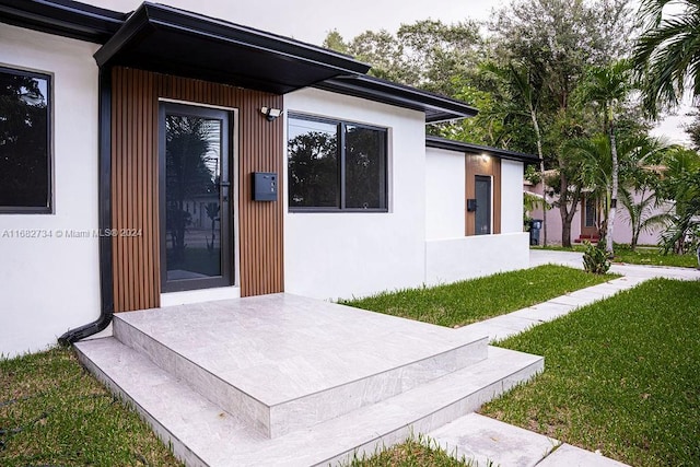 property entrance featuring a lawn