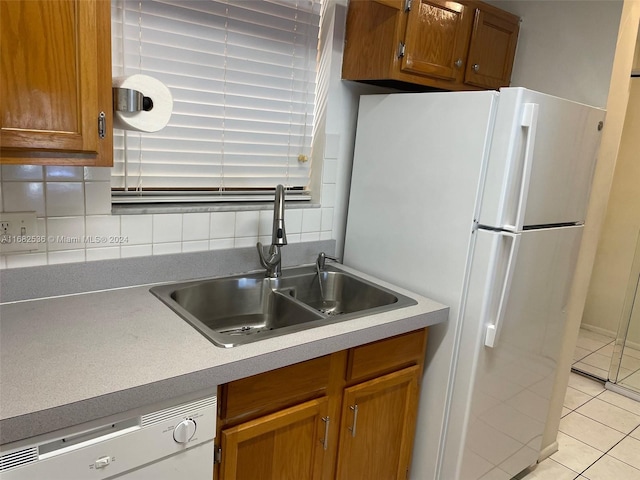 kitchen with tasteful backsplash, light tile patterned floors, dishwasher, sink, and white refrigerator