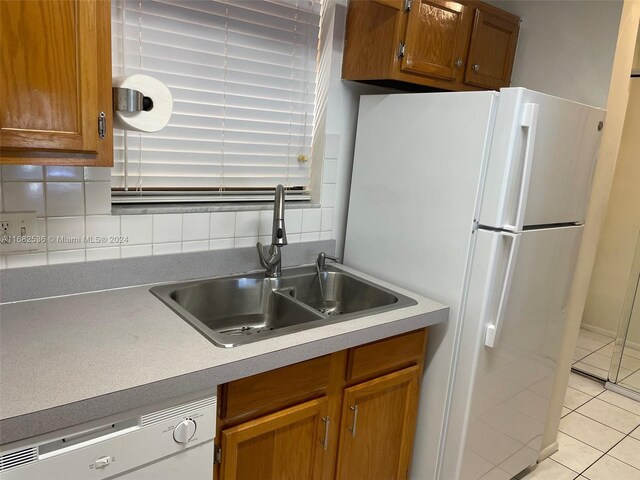 11453 NW 39th Ct Unit 308-2, Coral Springs, FL 33065 - kitchen featuring light tile patterned flooring, a sink, white appliances, brown cabinetry, and backsplash