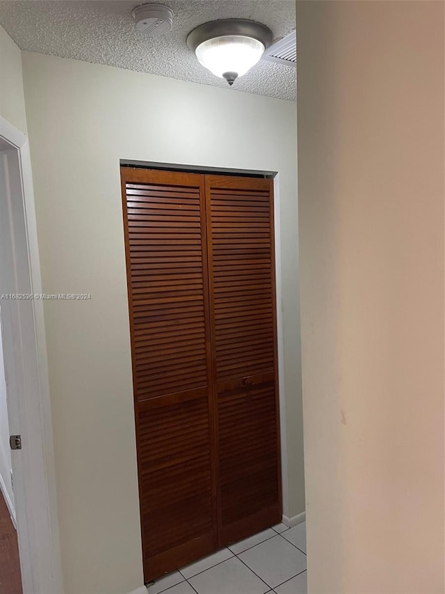 interior details featuring a textured ceiling and tile patterned floors