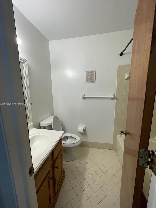 full bath with tile patterned flooring, bathing tub / shower combination, toilet, and vanity