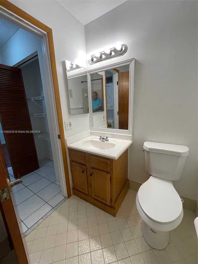 bathroom with vanity, tile patterned flooring, baseboards, and toilet