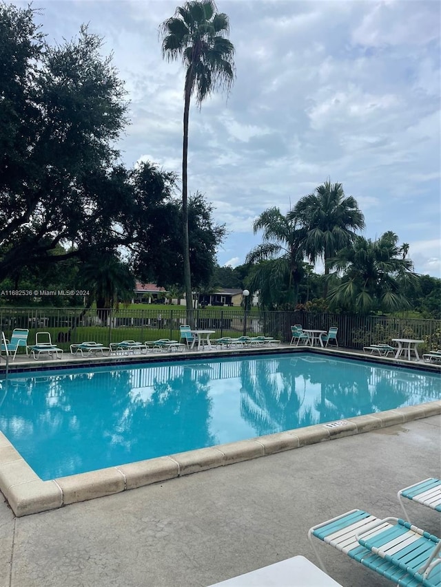pool featuring fence and a patio