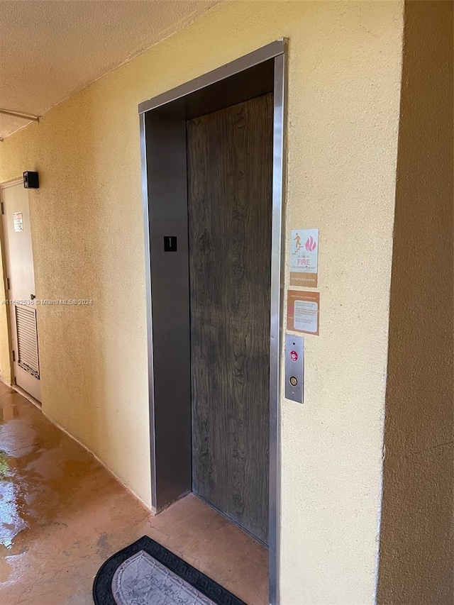 doorway to property featuring stucco siding and elevator