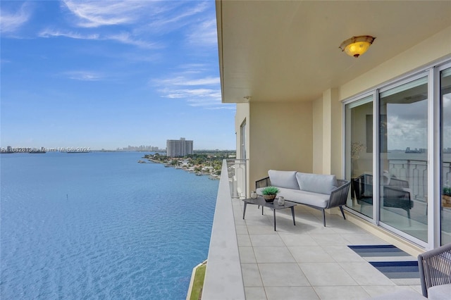 balcony with a water view, an outdoor living space, and cooling unit