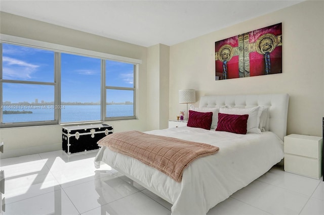 bedroom featuring a water view and light tile patterned floors