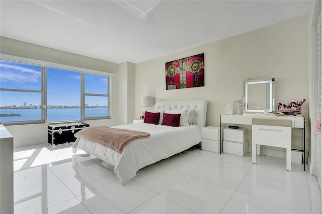 bedroom with a water view and light tile patterned floors