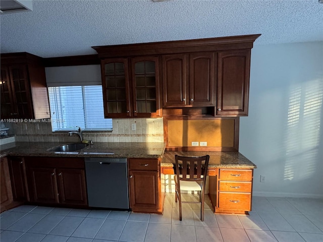 kitchen featuring dishwasher, sink, dark stone countertops, tasteful backsplash, and light tile patterned flooring